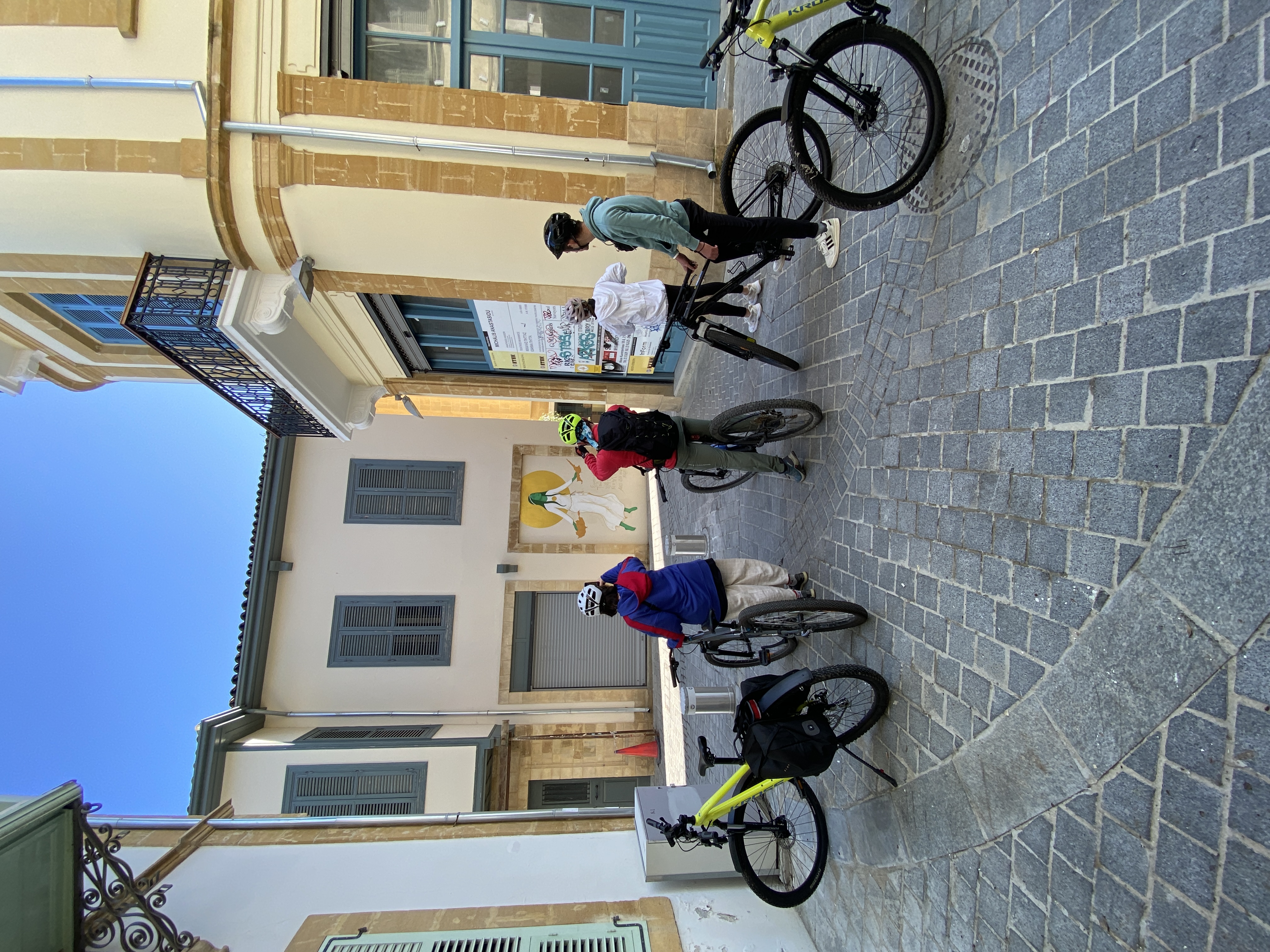Cyclists gathered by a street art mural in Nicosia